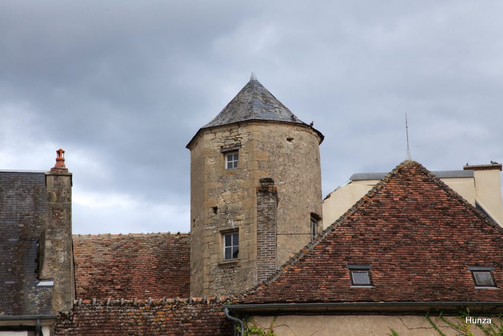 Tour du grenier à sel dépassant les toits à Moulins-Englibert