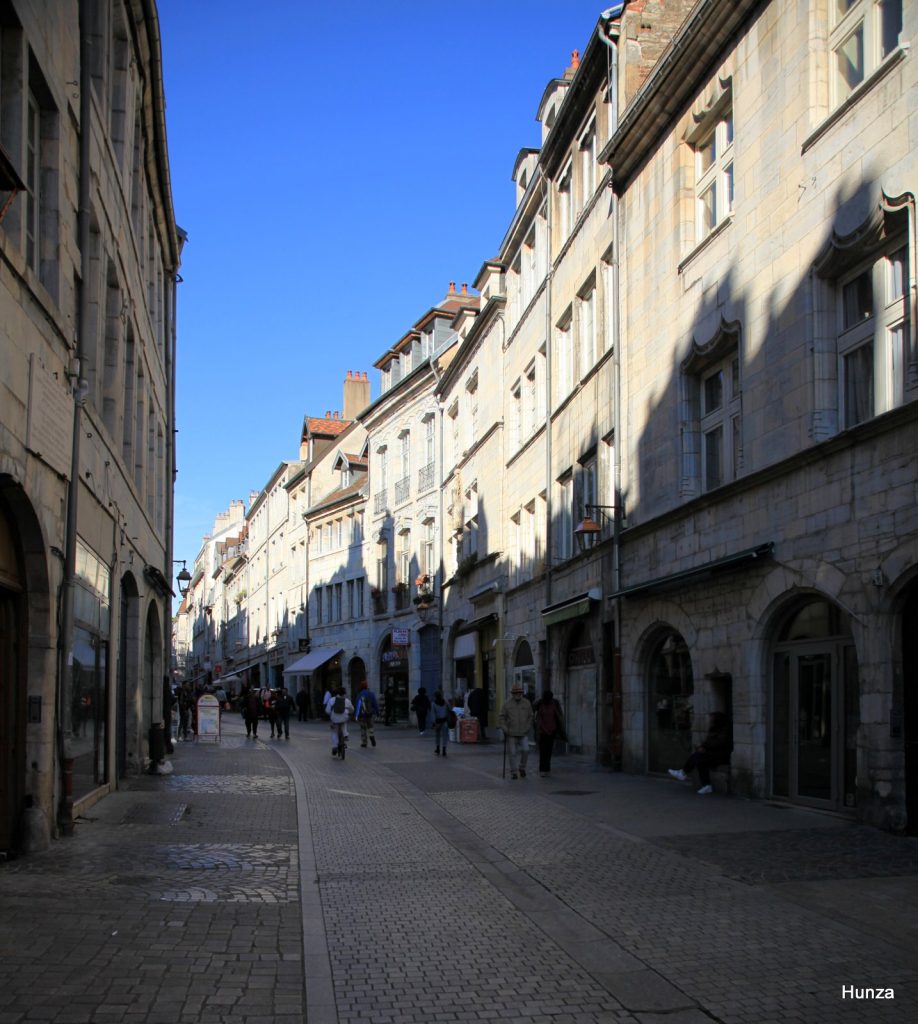 La rue Battant à Besançon avec une partie de ses immeubles éclairés par le soleil