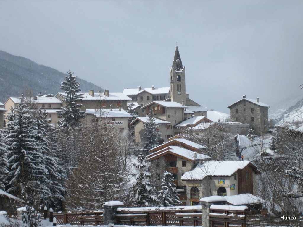 Centre-ville de Lanslevillard sous la neige et un ciel gris