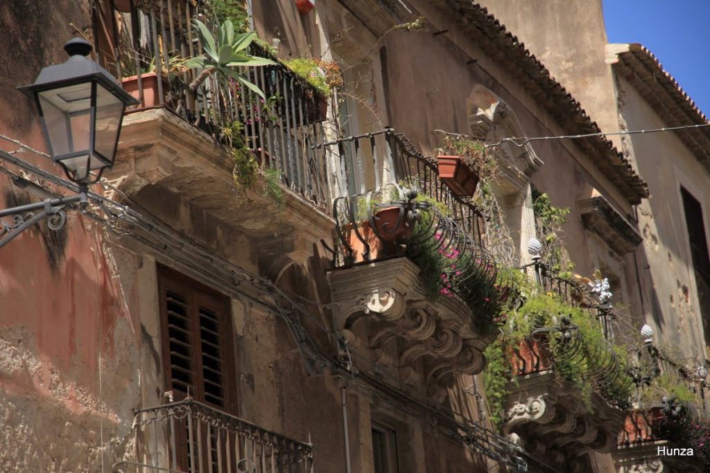 Balcons fleuris d'un palais ancien dans le centre historique d'Ortygie à Syracuse