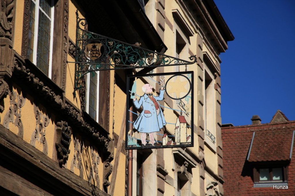 Enseigne en fer forgé « Preiss Zimmer », inspirée d'un dessin de Hansi, dans la rue du Général-de-Gaulle à Riquewihr.