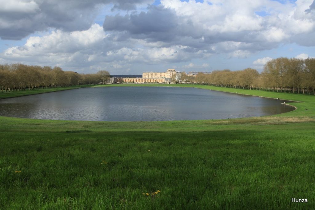 Vue sur la pièce d'eau des Suisses à Versailles avec le château au loin