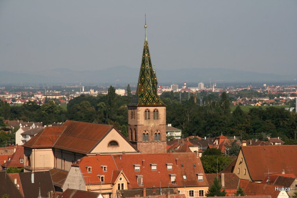 Clocher de l'église Sainte-Anne de Turckheim avec, en arrière-plan, la ville de Colmar