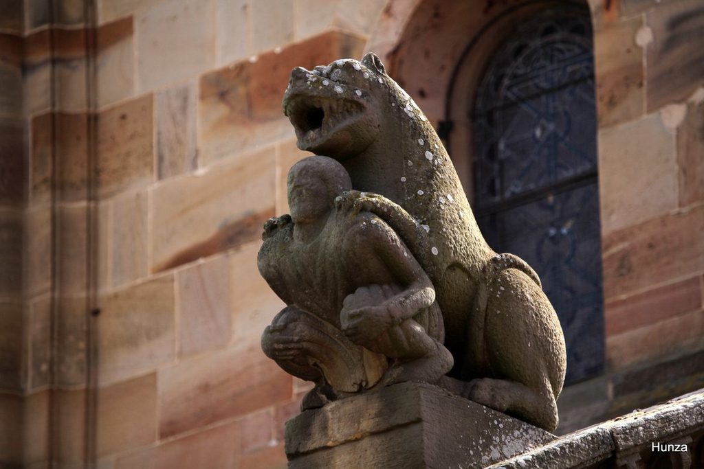 Acrotère représentant un animal tenant un personnage sur le côté nord de l’église de Rosheim