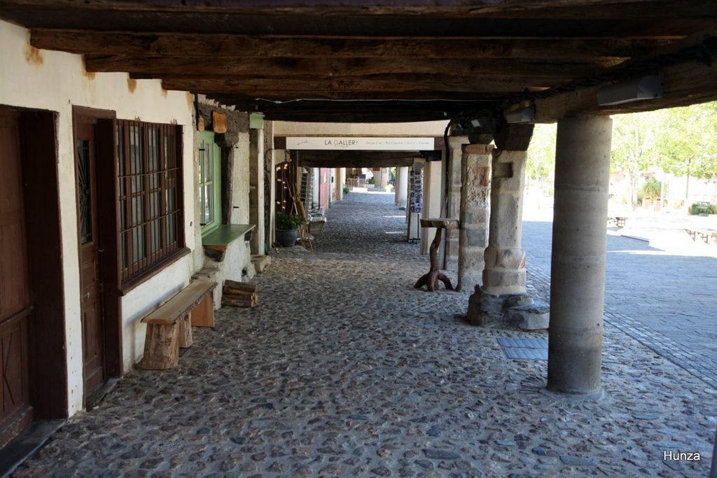 Sous les arcades des maisons de la place du Faubourg à Najac