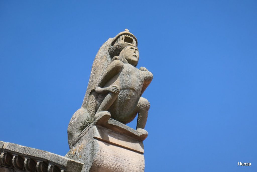 Lion tenant dans ses griffes une  femme nue sur un acrotère de l'église de Rosheim