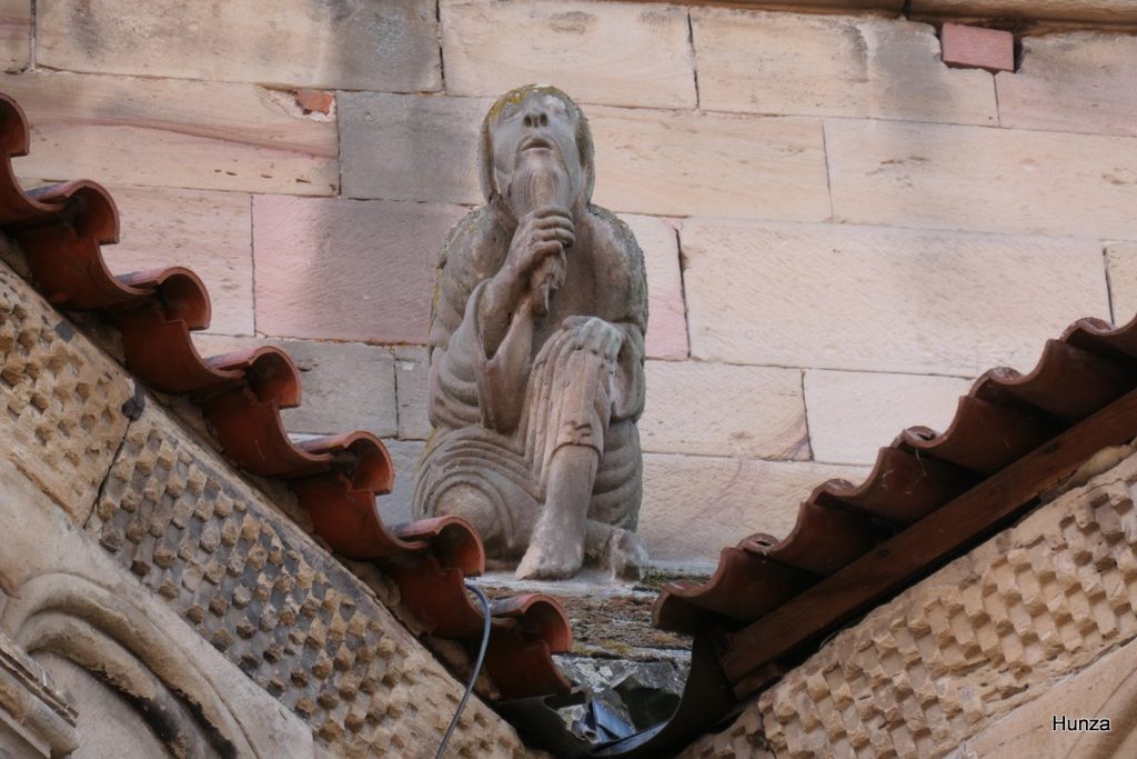 Personnage sculpté se lissant la barbe sur le glacis de la tour côté nord de l’église de Rosheim