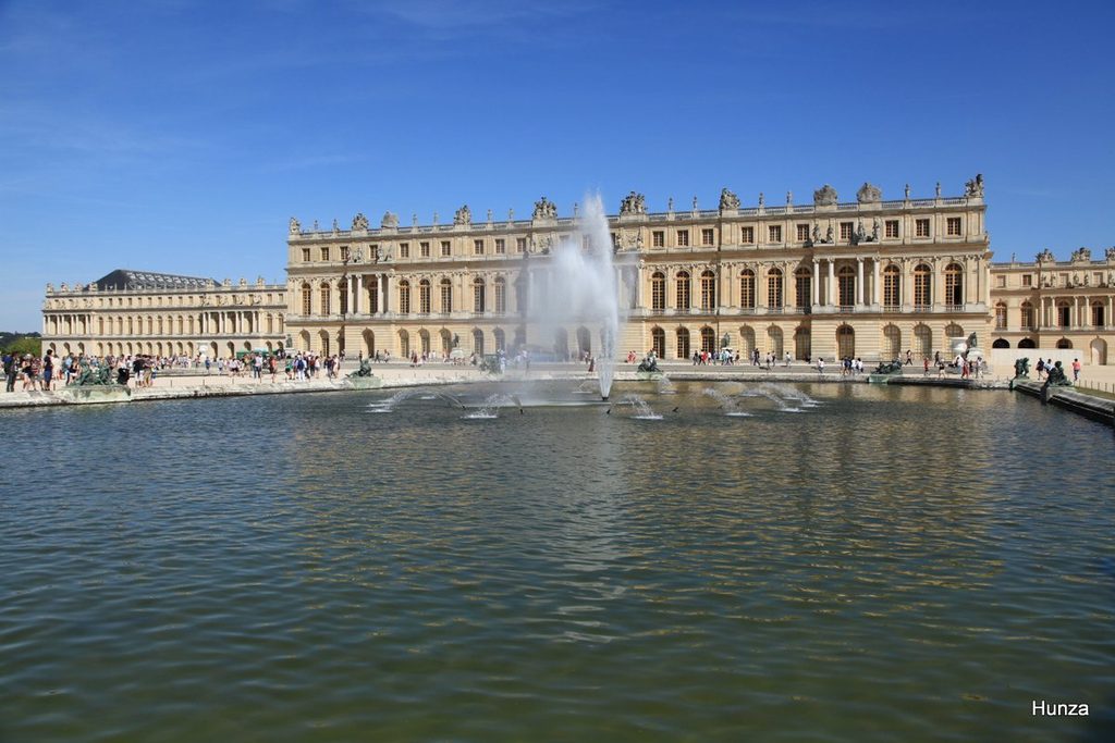 Château de Versailles et sa façade donnant sur le bassin de la fontaine, dans les jardins.